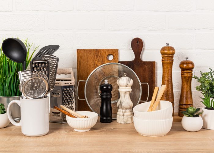 Various kitchen utensils made of natural materials, wood, metal, ceramics on a wooden kitchen countertop with potted plants. Eco-friendly cuisine